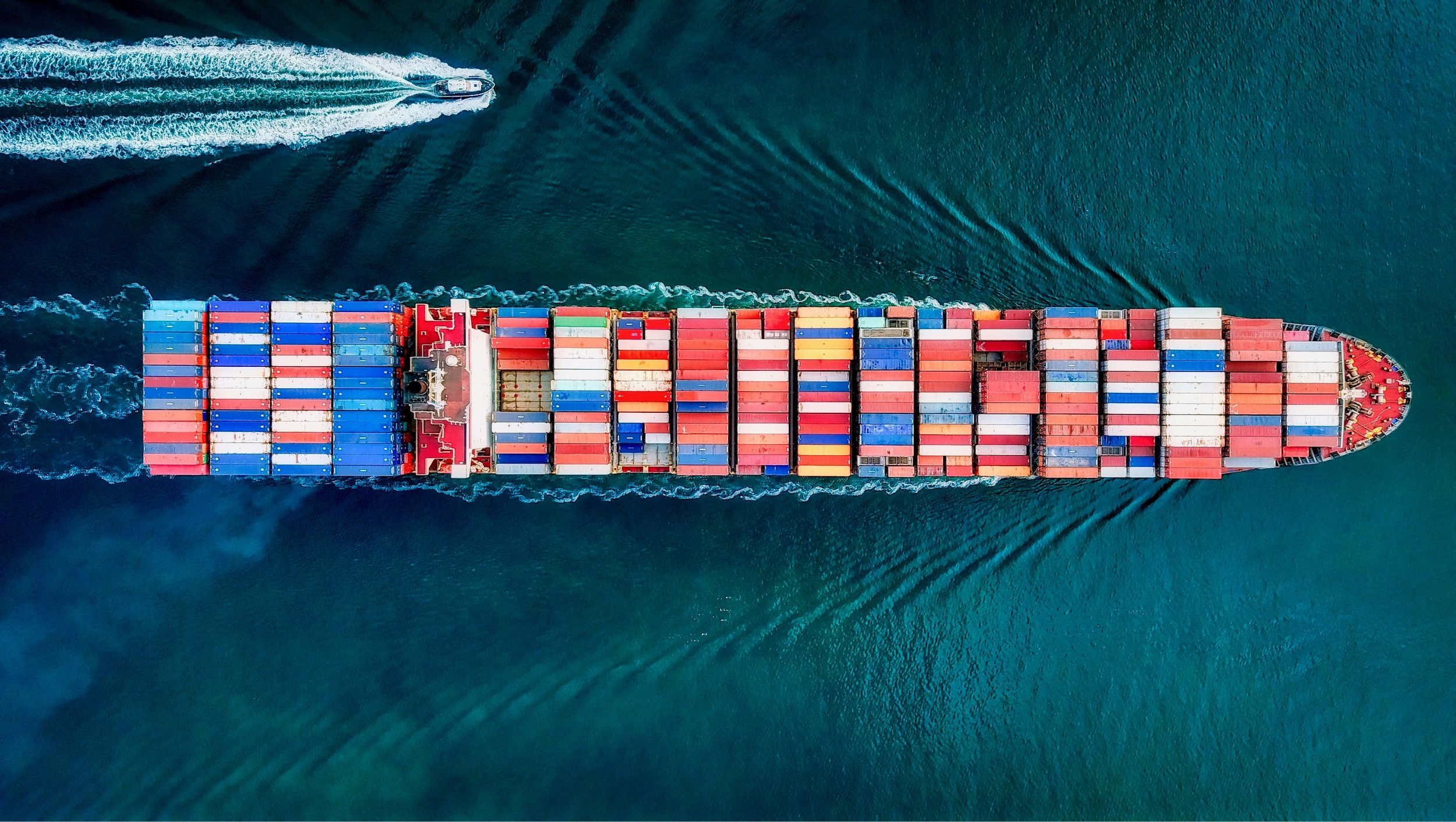 A cargo ship carrying containers across deep blue ocean water